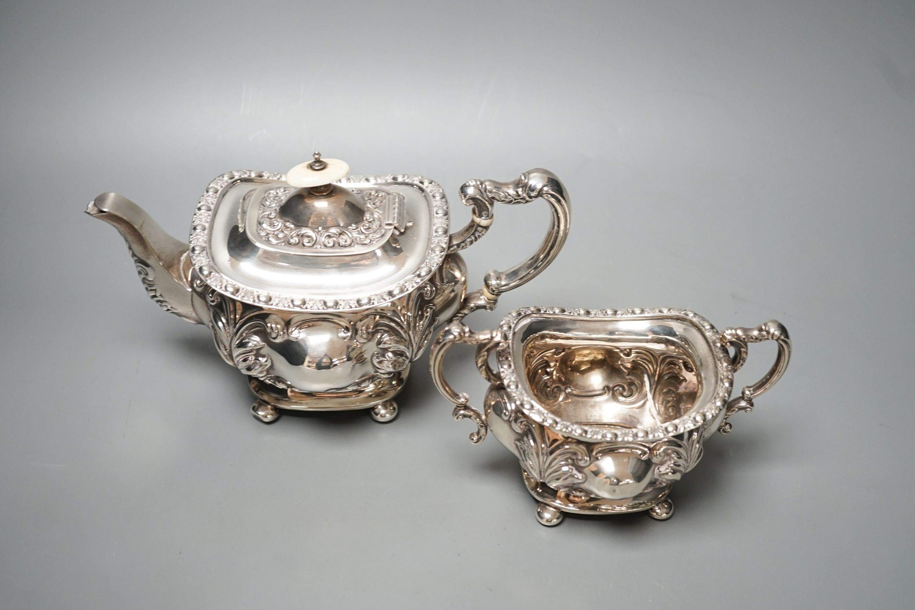 An Edwardian embossed silver teapot and matching sugar bowl, William Aitken, Chester, 1903, gross 21.5oz.